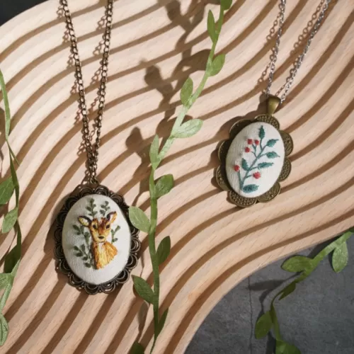 oval-shaped pendant necklace with vintage hand-embroidery, oval-shaped necklace, large pendant, elegant color scheme, exquisite design