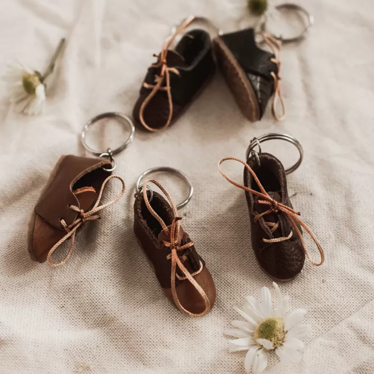 tiny leather shoes keychain, mini keychain, intricately detailed, suitable for decorating backpacks or bags