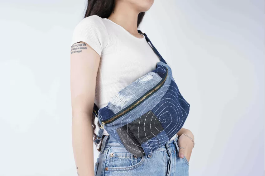 The crossbody bag has an impressive design from recycled jeans fabric